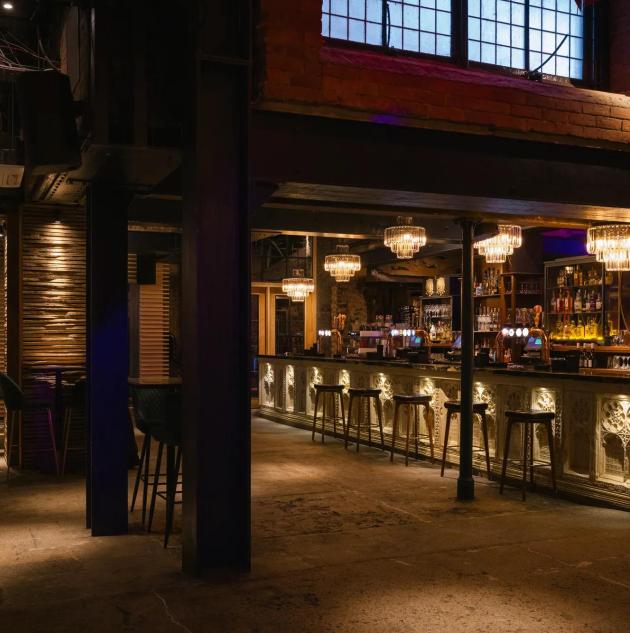 A wide angle view of an empty nightclub  in Newcastle upon Tyne in the North East of England. The club has an urban loft style theme with lots of exposed steel beams and open plan dance floor area.