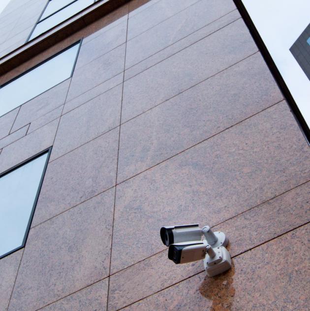 Security camera mounted on wall of tall building