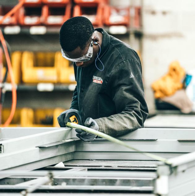 Man uses measuring tape in warehouse