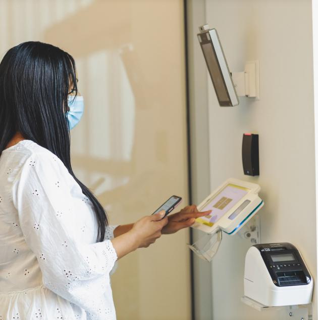 Woman uses phone with access control pad