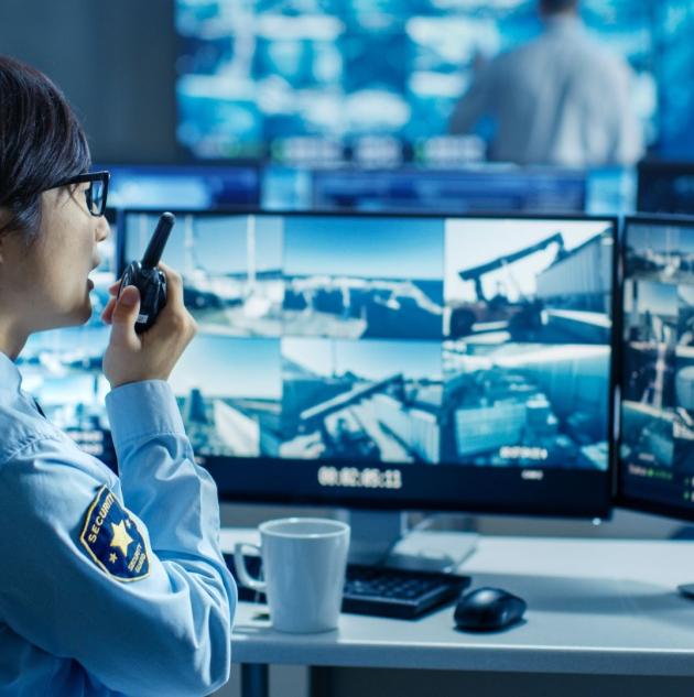 Security room officer monitors screens