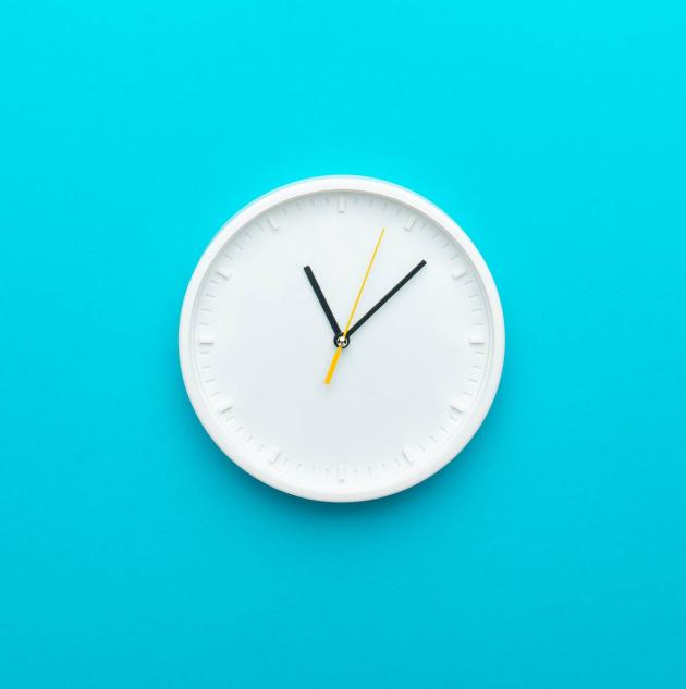 Clock hanging on blue wall