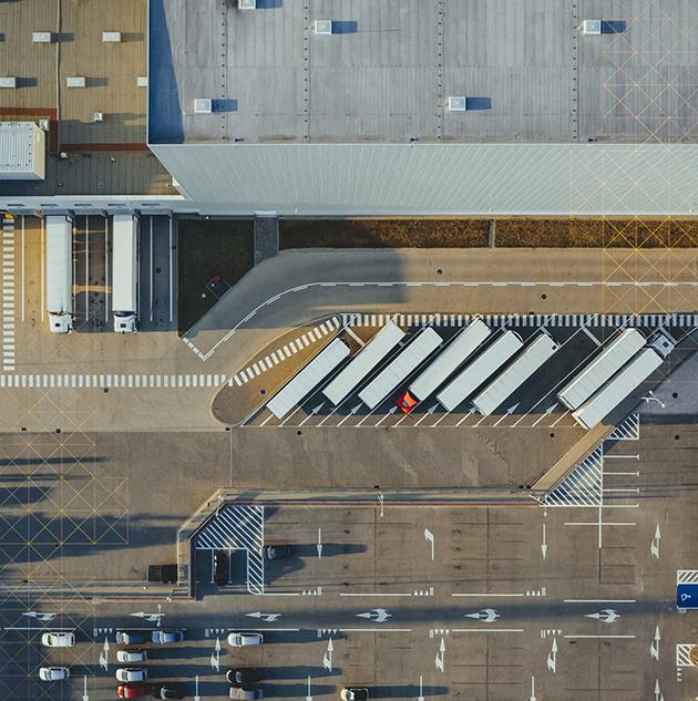Aerial view of trucks parked outside warehouse.