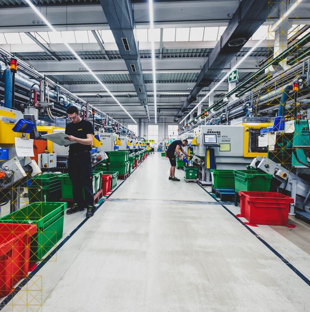 Two men work at manufacturing machines.