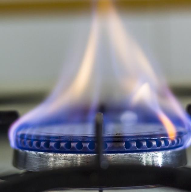 Close up of flame under gas stove burner.