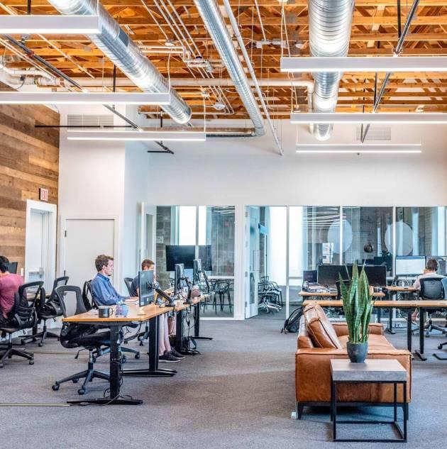 large open office setting with desks and workers on computer 