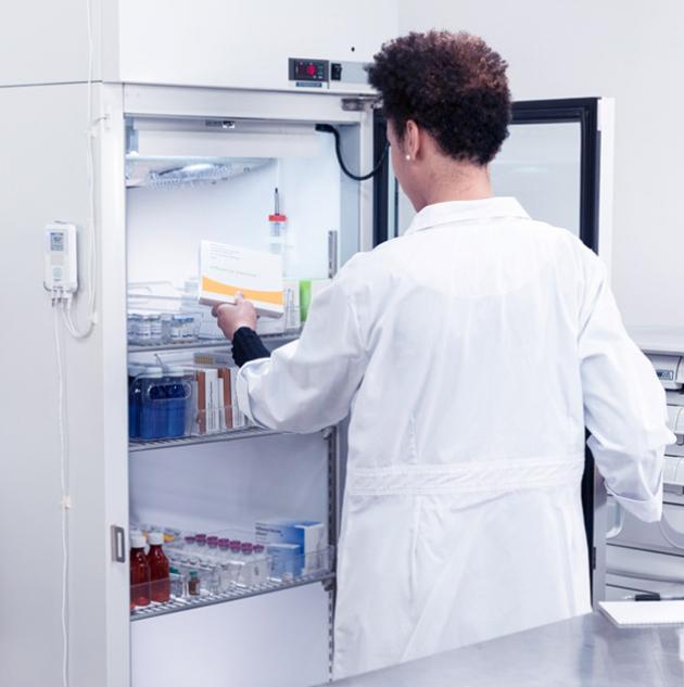 A lab technician removing an item from a cold storage unit