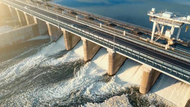 Hydroelectricity power station gates with flowing water, aerial view.