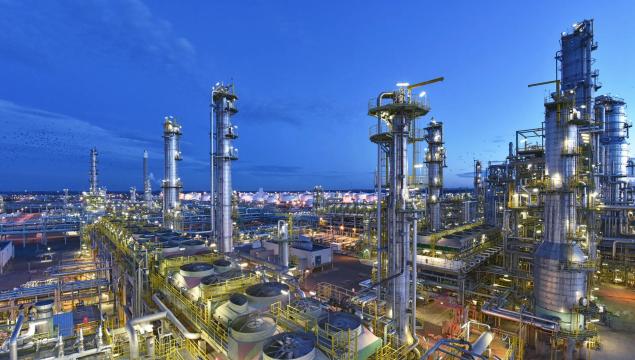 refinery - chemical factory at night with buildings, pipelines and lighting - industrial plant
