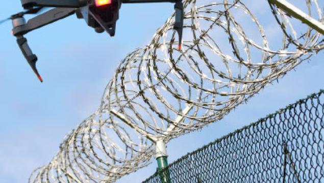 Drone shot flyover of barbed wire with a drone in the shot