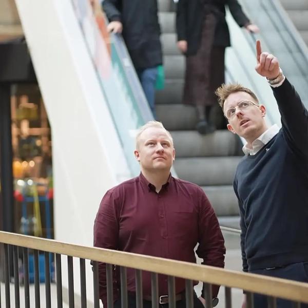 En man från Securitas Technology pekar och berättar om modern säkerhetsteknik för sin kund