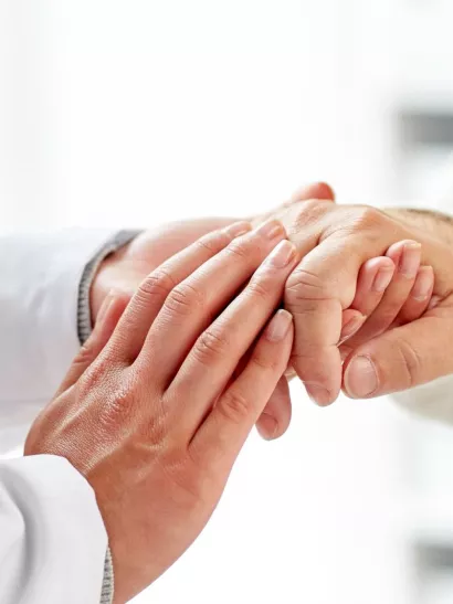 Doctor holds hands of patient