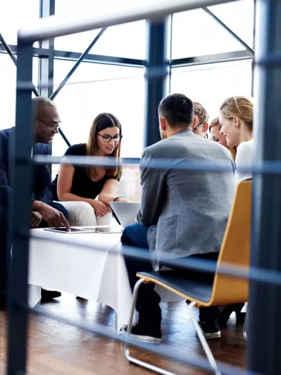 Employees sit around table