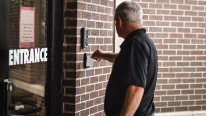 person swiping card reader on door using commercial smart lock access control credentials