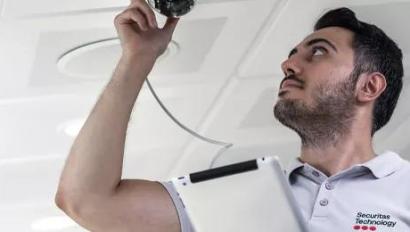 Securitas technician installing a security camera