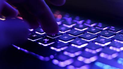 Travail sur un clavier d'ordinateur en néon avec rétro-éclairage coloré. Jeux vidéo, piratage, technologie, internet. Focus sélectionné. Photo de haute qualité