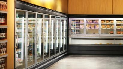 a row of commercial freezers filled with frozen food, highlighting the role of artificial intelligence in retail inventory management