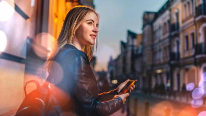 Kvinna använder mobiltelefon för att aktivera personlarm – en del av vår lösning för personlig säkerhet & larm i vardagen