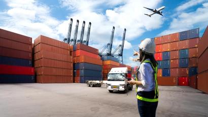 Foreman Woman control loading Containers box from Cargo freight ship for import export.