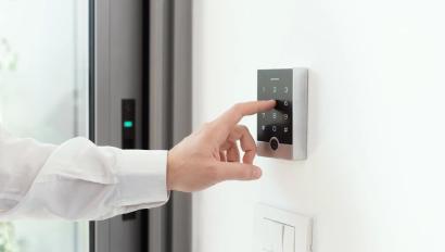 Man setting an alarm code for home security, alarm system concept