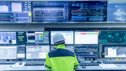 Technician monitoring control room technology to enhance energy security for critical infrastructure.