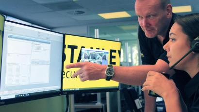 Security employee points toward monitor