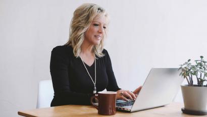 Woman in business casual attire on laptop