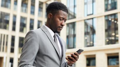 Man in suit looks at phone screen