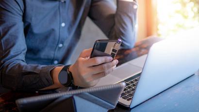 Person using smartphone and laptop