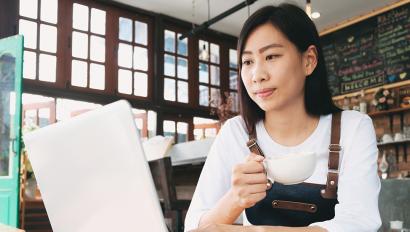 Cafe owner looks at laptop screen