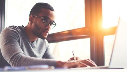 Man uses laptop in front of sunlit window