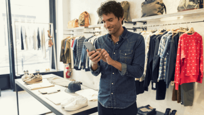 Man uses smartphone in retail shop