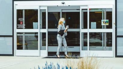 Woman entering building through external door using access control card