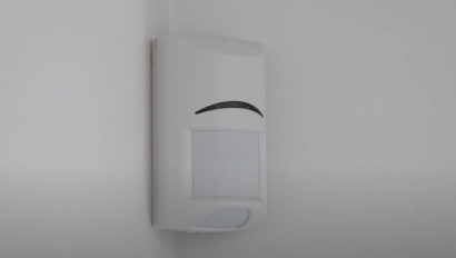 Motion sensor mounted in corner of room.