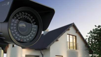 Security camera in front of beige home.